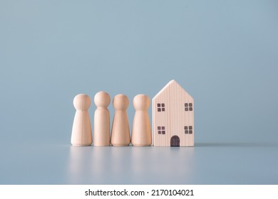 Small Wooden Faceless Figures Of Human Family Members And House. Property, Hospitality, Orphanage Concept Using Wooden House And Human Model.