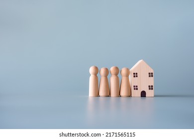 Small Wooden Faceless Figures Of Human Family Members And House. Property, Hospitality, Orphanage Concept Using Wooden House And Human Model.