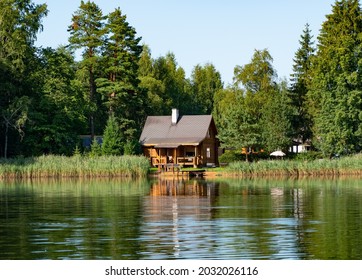 Small wooden fishing or sauna hut by the calm lake in middle of the forest. Small log cabin  near the bond. Perfect sunny warm summer day in Estonia. Amazing reflection on the lake. - Powered by Shutterstock