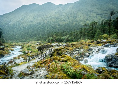 A small wooden footbridge crosses the Prek Chu river of West Sikkim at Kokchurang. - Powered by Shutterstock