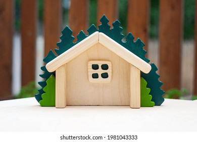 Small Wooden Handmade Dollhouse With Green Spruce On The Back. Handcrafted Wood Waldorf Toy For Kids. Open Forest Cabin With Window