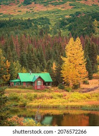 Small Wooden House In Autumn Forest, Alaska, USA.