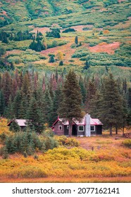 Small Wooden House In Autumn Forest, Alaska, USA.