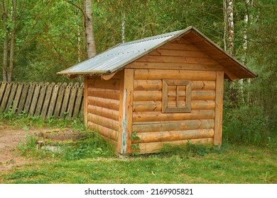 A small wooden house with a fake window on the lawn