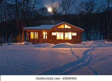 A Small Wooden House In A Snowy Forest