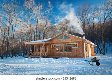 A Small Wooden House In A Snowy Forest