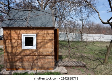 Small Wooden House Stands In Backyard Of Private House. Outdoor Playhouse For Children. Spring. Outdoor.