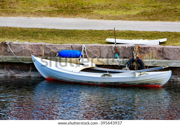 A small wooden hunting\
canoe is moored and tied beside the stone pier. This kind of canoe\
is often used when fishing or hunting in the southern Swedish\
archipelago.