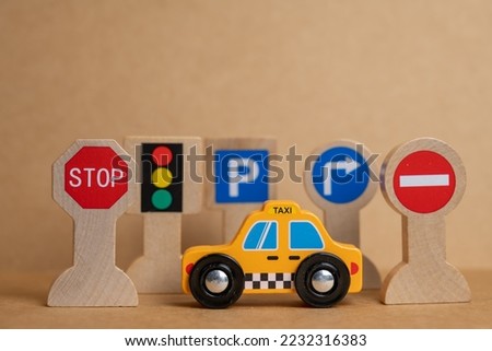 small wooden taxi in front of road signs