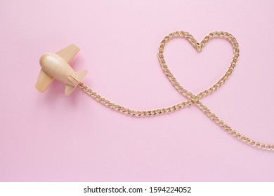 Small Wooden Toy Airplane Carries In The Shape Of A Heart From A Gold Chain