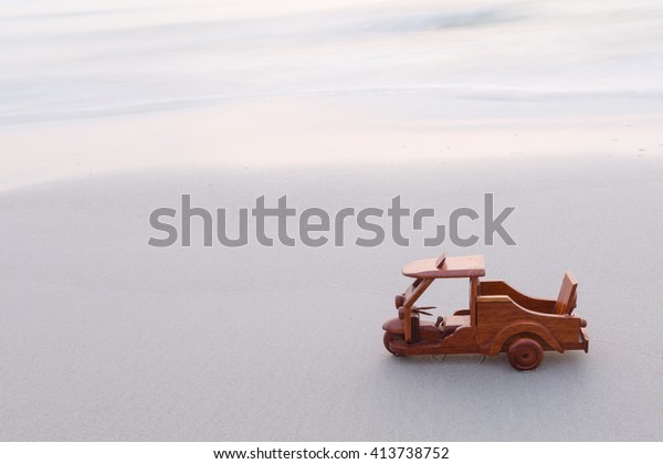 Small wooden\
toy car (Tuk Tuk Thailand) on\
beach