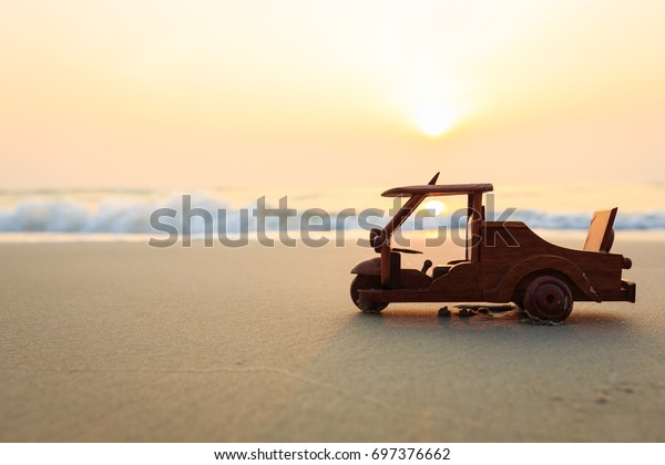 Small wooden\
toy car (Tuk Tuk Thailand) on\
beach