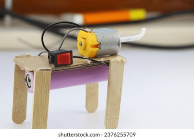 Small working robot model made using DC motor and a battery. Mini educational robots built at home with recycled materials