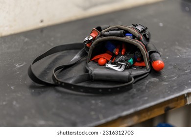 A small workshop bag lying on the workbench.