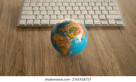 Small world globe in front of a computer keyboard representing global technology - Powered by Shutterstock - Get 15% off with code: PIKWIZARD15