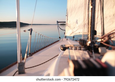 Small Yacht Sailing On A Lake With Smooth Water In Summer During Sunset 