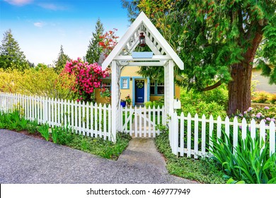 Small Yellow house exterior with White picket fence and Decorative Gate. Northwest,USA