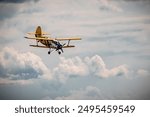 Small yellow propeller plane in the sky. Landing airplane. Private cessna plane in clouds. 