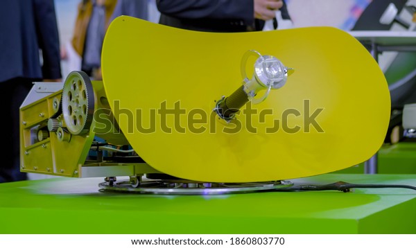 Small yellow rotating satellite dish antenna,\
VSAT parabolic receiver using to receive or transmit information at\
telecommunication exhibition. Broadcasting, communication,\
technology concept
