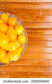 Small Yellow Tomatoes In A Glass Bowl. Closeup Image Of Yellow Pear Tomatoes. View From Above. Organic Healthy Food.