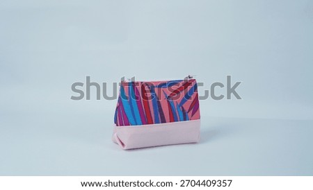 Small zip pouch with bold abstract leaf pattern and pastel pink base on a plain backdrop.
