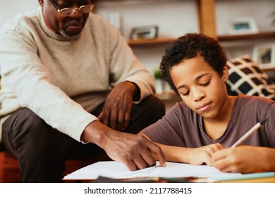 Smart African Boy Doing His Math Homework With A Little Help Of His Grandpa. Tutoring And Education