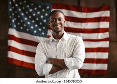 A Smart African-American Man, Young Successful Entrepreneur Crossed His Arms Smiling Amid America's National Flag, Patriotism Concept - Shutterstock ID 1645310053