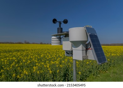 Smart agriculture and smart farm technology. Meteorological instrument used to measure the wind speed and solar cell system in the raps field. Weather station with solar panel placed in the field. - Shutterstock ID 2153405495