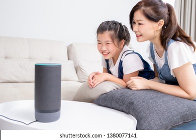 Smart AI Speaker Concept - Mom And Daughter Talk To Voice Assistant At Home And Feel Happy 