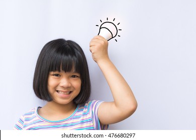 Smart Asia Kid Hold LED Bulb In Her Hand. Happy Smiley Asian Girl Child Having An Idea Concept On White Background.Positive Thinking. Universal Children's Day.World Thinking Day