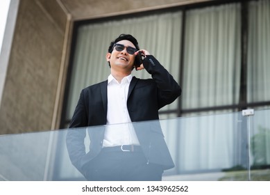 Smart Asian Businessman Talking With Phone With Building Background, Lifestyle Concept.