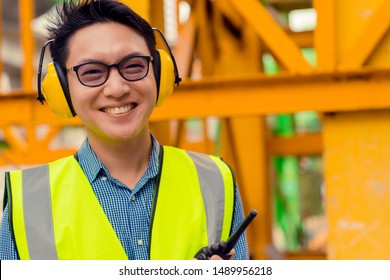 smart asian engineer manager with safety uniform checking site construction with steel and concrete sturcture background