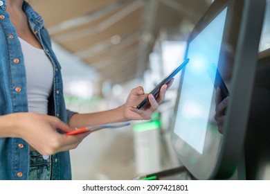smart asian female traveller self checking in for flight transport at gate counter machine scaning monitor device at airport check in counter,smart technology travel ideas concept at terminal