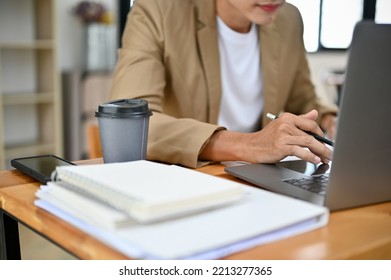 Smart Asian Male CEO Or Boss In Casual Suit Working At His Desk, Using Laptop Computer, Typing On Keyboard. Cropped Image