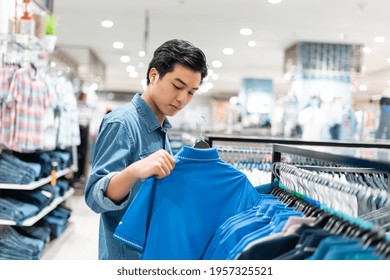 The Smart Asian Man Is Choosing Clothes In The Clothing Store In The Mall,