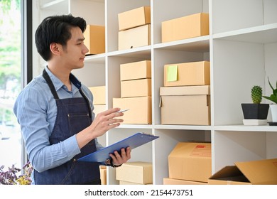 Smart Asian Millennial Male Online Business Owner Checking His Product Stock In The Stock Room. SME Startup Business Entrepreneur.