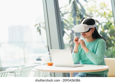 Smart Attractive Asian Female Business Owner Weared Virtual Reality Glasses Enjoys Casual Metaverse Meeting With Concentrate At Cafe Restaurant,asian Female  Using Oculus Rift Headset In Cafe