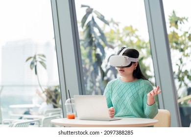 smart attractive asian female business owner weared virtual reality augmented reality glasses enjoys casual metaverse meeting with concentrate at cafe,asian female wear headset goggle gear in cafe - Powered by Shutterstock