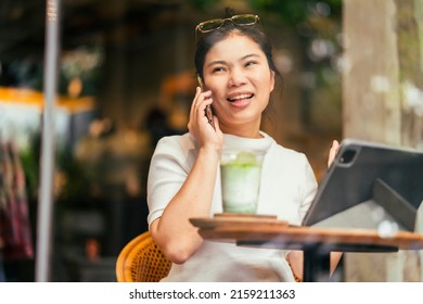 Smart Attractive Positive Asian Digital Nomad Female Wearing Casual Cloth Work Remote New Normal Lifestyle Hand Use Tablet Tele Conference Onlive Videocall Meeting Remote At Coffeeshop Cafe Restaurant