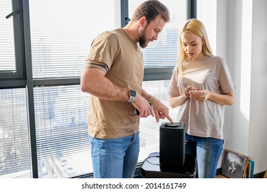 Smart Audio Speaker. Voice Assistant Helper At Home Used By Young Family Couple. Portrait Of Caucasian Man And Woman Use Modern Technology Innovation Device. Copy Space