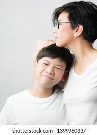 A Smart And Beautiful Asian Mom Holding Her Preteen Son With Love. Her Son Leans His Head On Her Chest Smiling Happily. Love Expression, Parenting Teen, Single Mom, Young Son, Mommy Love Concept.