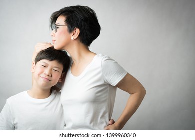 A Smart And Beautiful Asian Mom Holding Her Preteen Son With Love. Her Son Leans His Head On Her Chest Smiling Happily. Love Expression, Parenting Teen, Single Mom, Young Son, Mommy Love Concept.