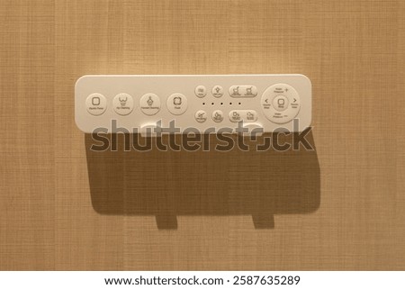 Smart bidet remote control, electronic toilet operation panel on wooden wall. toilet with electronic seat automatic flush, japan style toilet bowl, high technology sanitary ware.