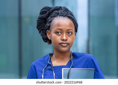 Smart Black Girl Medical Student In Glasses, Young African American Woman Nurse, Doctor In Blue Uniform, Stethoscope, Smiling Afro Female At University, College, Hospital, Clinic. Copy Space