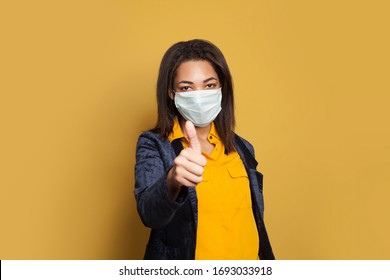 Smart Black Woman In Medical Mask Showing Thumb Up On Yellow Background