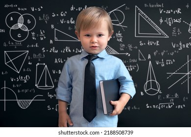 a smart boy in a school uniform, standing at the blackboard with mathematical signs, graphs and formulas. Smart, brilliant children. The concept of education - Powered by Shutterstock