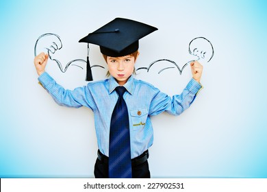 Smart boy stands by the whiteboard in a classroom expressing the power of knowledge. Educational concept. Copy space.