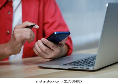 smart businessman with red shirt and working with laptop smartphone while working on his project - Shutterstock ID 2170584829