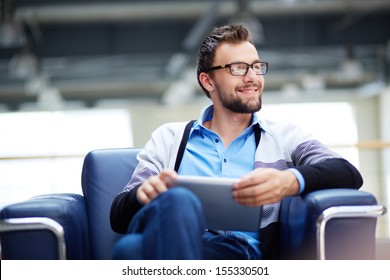 Smart businessman with touchpad thinking of new idea or strategy in office
