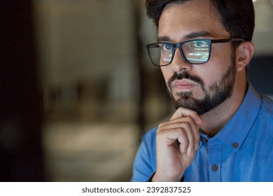 Smart busy young business man software developer engineer programmer wearing eyeglasses looking at computer. Coder working with ai software development solutions. Code glasses reflections. Copy space.